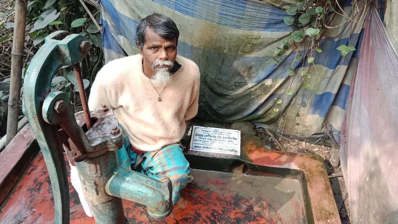 Man operating a deep tube-well / water pump.
